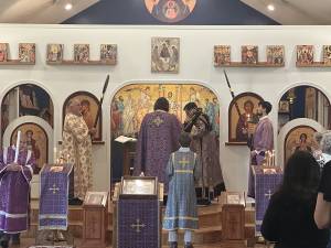 St. Mary Magdalene Church service with priests in purple robes holding candles and icons on display, worshippers attending ceremony