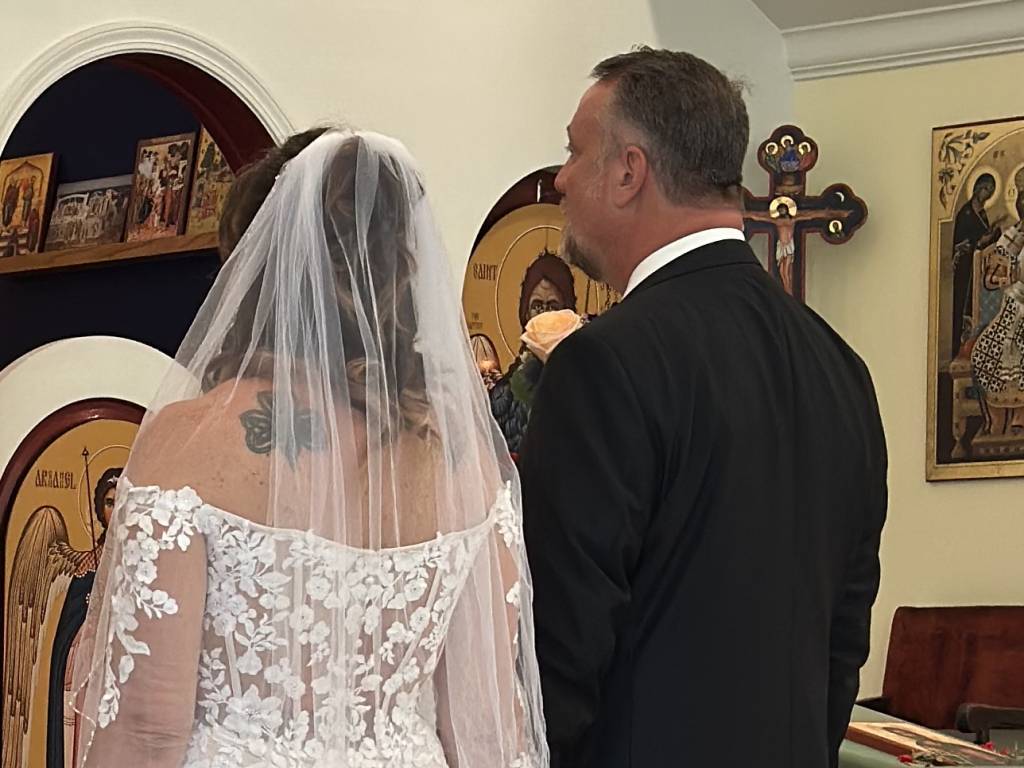 Bride and groom in St. Mary Magdalene church ceremony with religious icons in the background