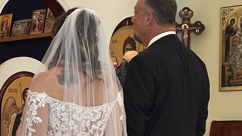 Bride and groom in St. Mary Magdalene church ceremony with religious icons in the background