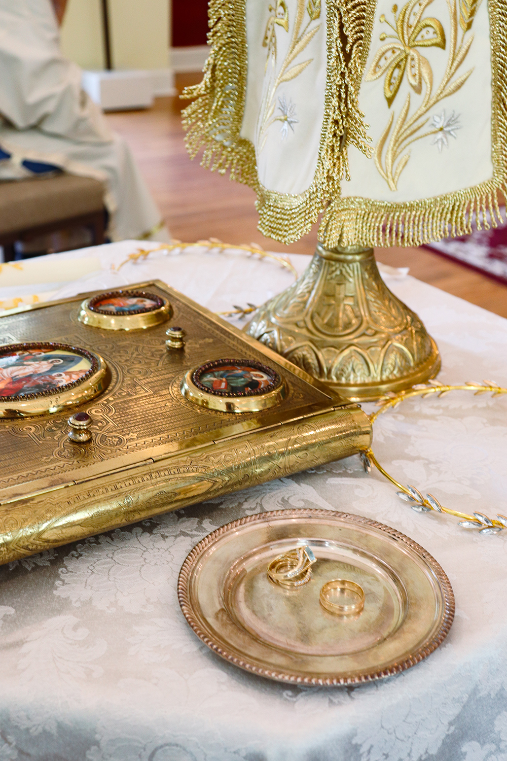 Golden ceremony items on a decorative table with embroidered cloth and ornate metal decorations