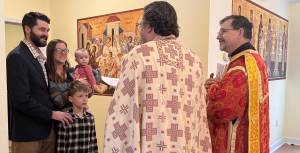 Family gathering with clergy in religious setting, colorful iconography background