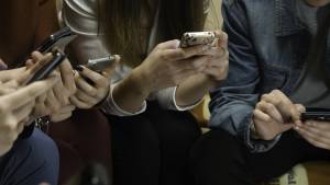 People using smartphones together, focusing on screens, illustrating modern digital connectivity and social interaction
