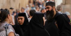 Group of people in traditional religious attire having a conversation in a crowded outdoor setting