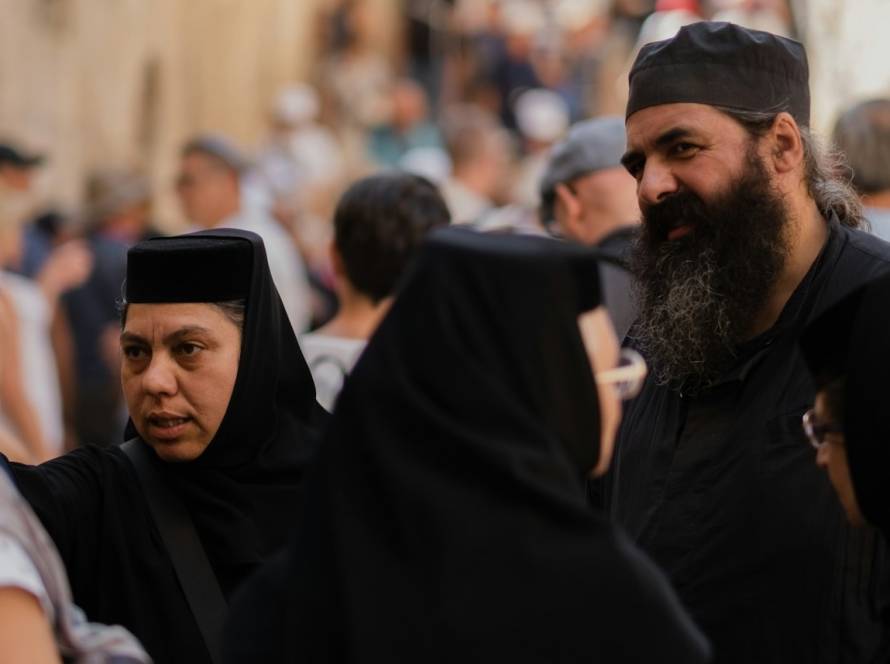 Group of people in traditional religious attire having a conversation in a crowded outdoor setting