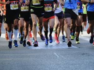Group of runners competing in a marathon, showcasing colorful athletic shoes and dynamic movement on a city street