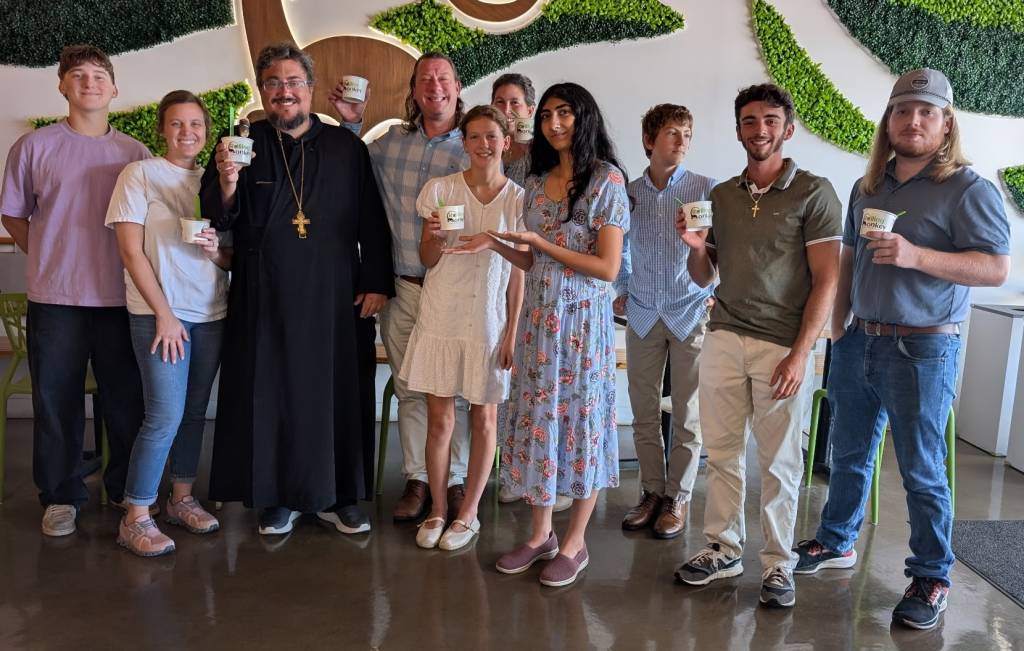 Group enjoying frozen yogurt at ChillOut Monkey, smiling and holding cups in a vibrant cafe setting