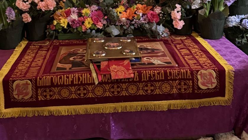 Orthodox religious altar adorned with iconography and surrounded by vibrant flowers