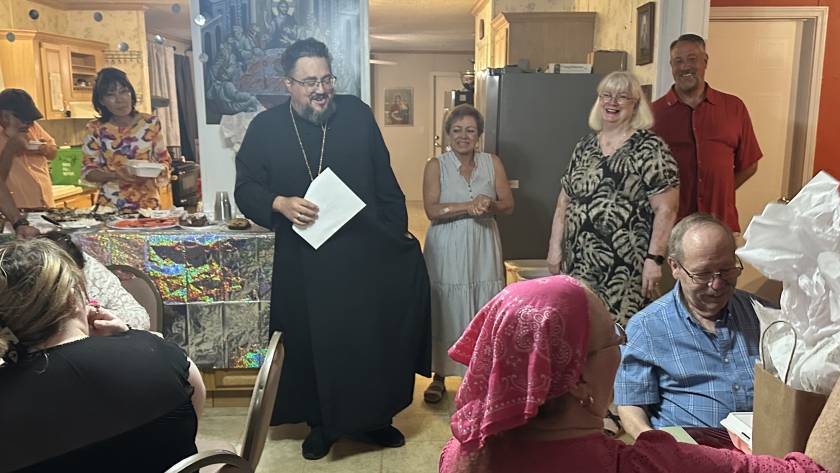 Community gathering with diverse group enjoying food and conversation in a cozy kitchen setting