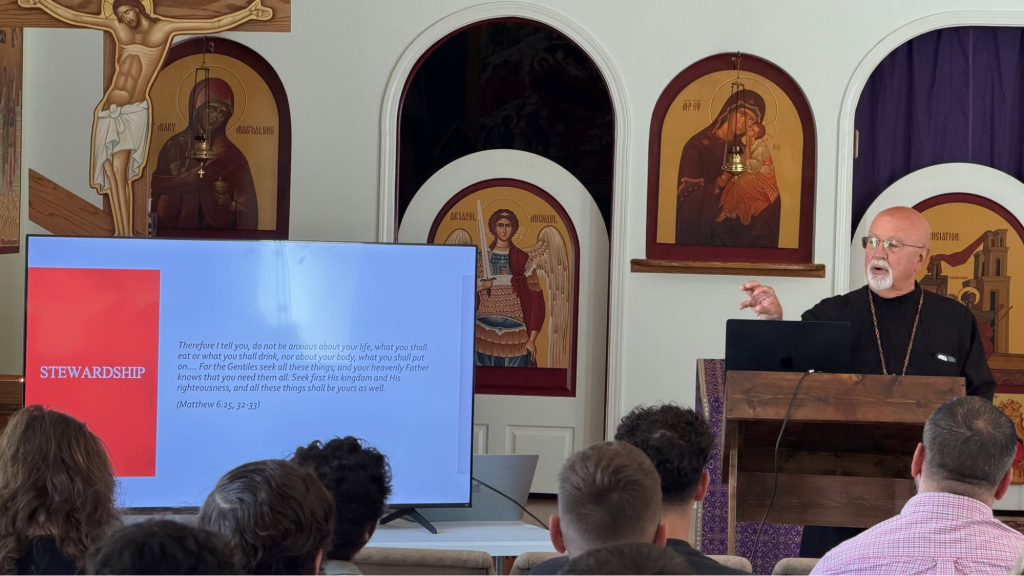 Speaker giving a presentation on stewardship with religious icons in the background