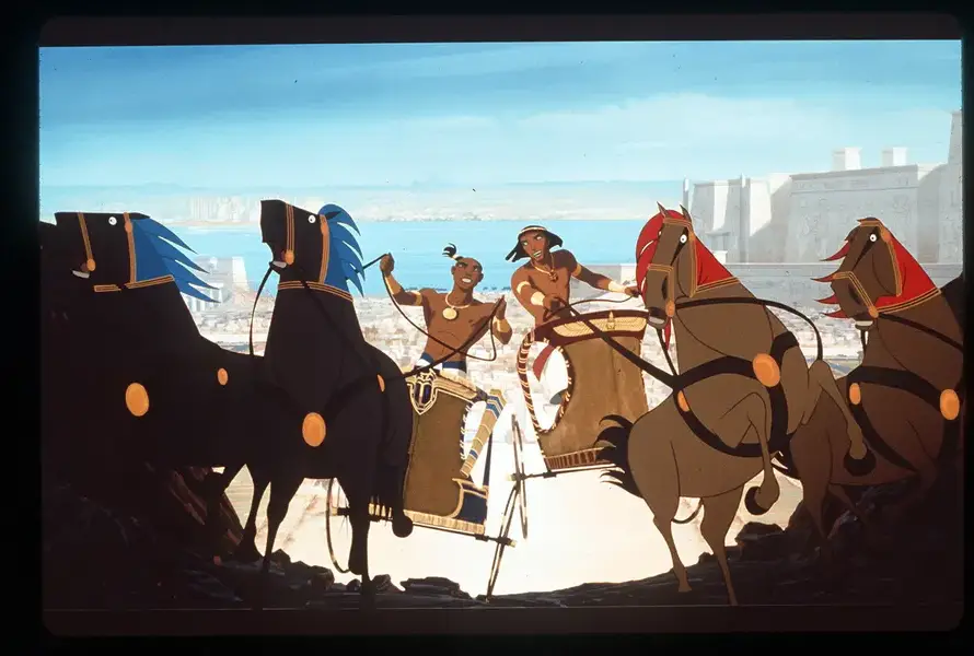 Animated characters in ancient chariot race with horses, set against a backdrop of Egyptian-style architecture and a blue sky